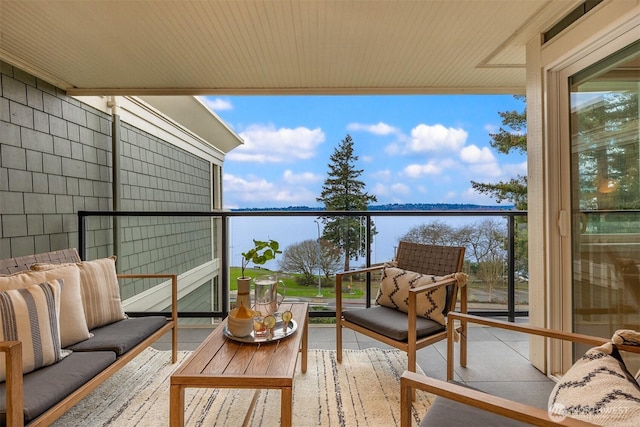 balcony featuring outdoor lounge area and a water view