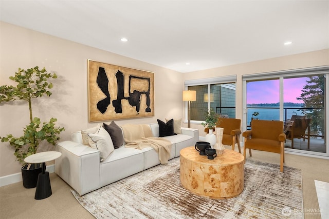 living area with carpet flooring, recessed lighting, and a water view