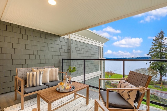 balcony with a water view and an outdoor hangout area
