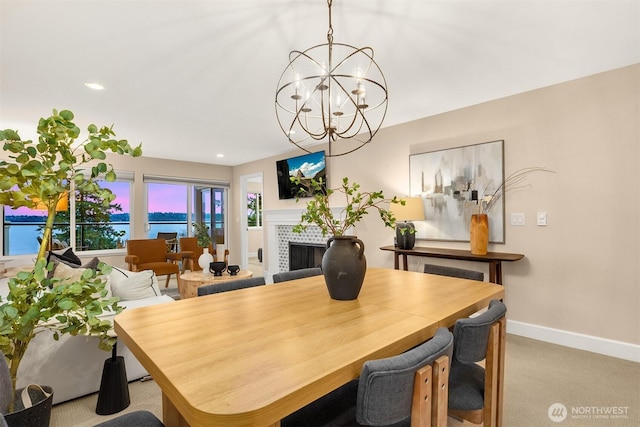 carpeted dining room with baseboards, a notable chandelier, a tile fireplace, and recessed lighting