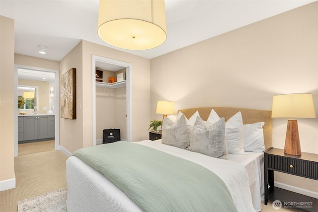 bedroom featuring carpet, baseboards, and ensuite bathroom