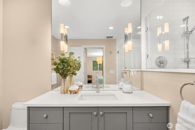 ensuite bathroom with a tile shower, ensuite bath, vanity, and visible vents