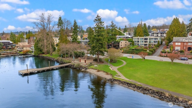 surrounding community featuring a floating dock, a yard, and a water view