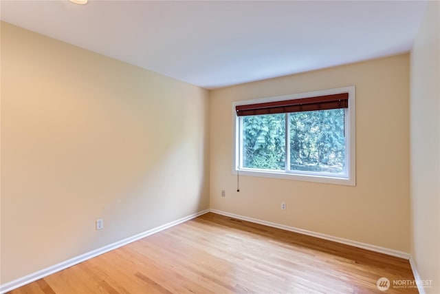 unfurnished room featuring baseboards, visible vents, and light wood finished floors