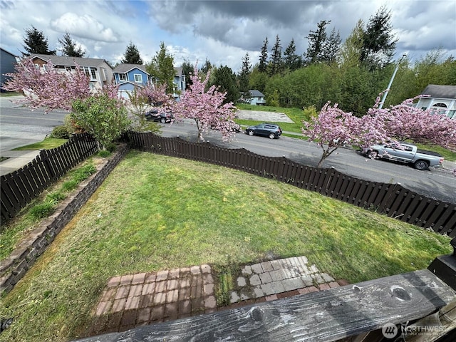 view of yard featuring fence and a residential view
