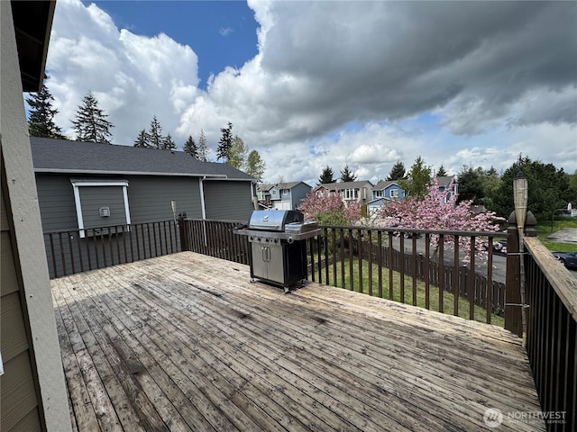 deck with area for grilling and a residential view