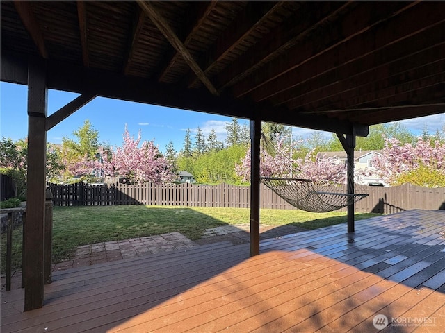 wooden terrace with a fenced backyard and a yard