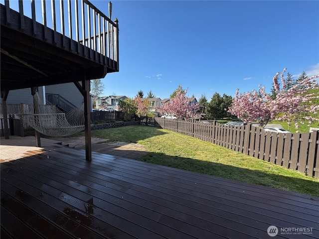 deck with a fenced backyard, a residential view, and a yard