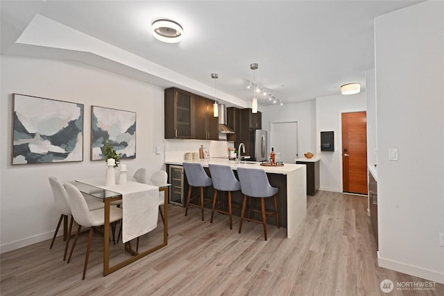 1760 NW 56th St Unit 601, Seattle, WA 98107 - kitchen with a sink, light wood-type flooring, freestanding refrigerator, a kitchen bar, and light countertops