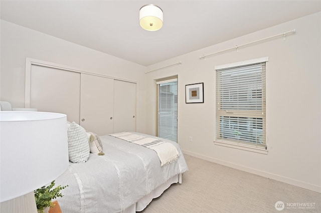 1760 NW 56th St Unit 601, Seattle, WA 98107 - bedroom featuring baseboards, light carpet, and a closet