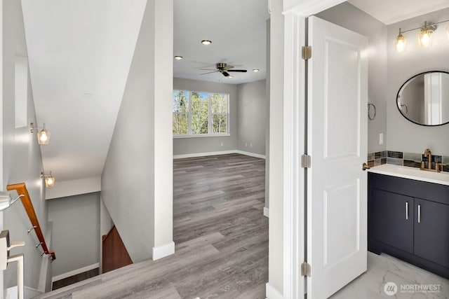 interior space featuring recessed lighting, wood finished floors, vanity, baseboards, and ceiling fan