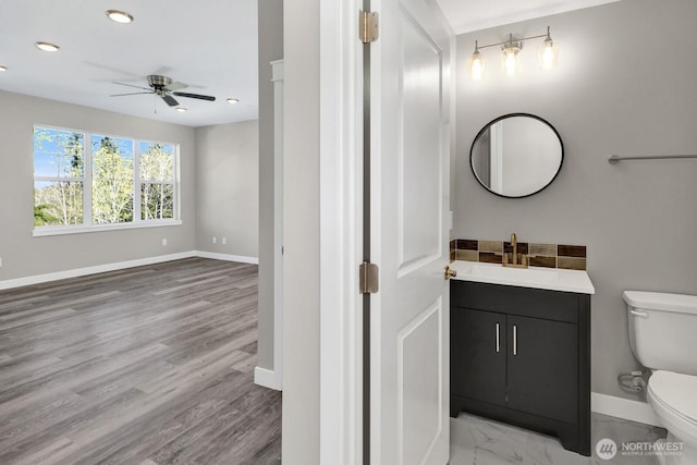 bathroom with toilet, baseboards, recessed lighting, a ceiling fan, and vanity