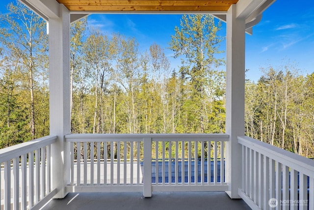 balcony featuring a wooded view