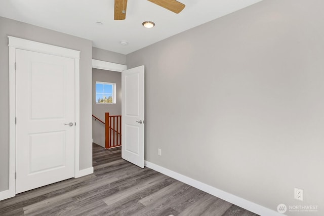 unfurnished bedroom featuring baseboards, wood finished floors, and ceiling fan