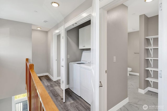 laundry area featuring marble finish floor, washing machine and clothes dryer, cabinet space, and baseboards