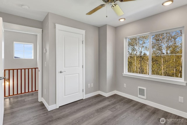 unfurnished bedroom with visible vents, baseboards, and dark wood finished floors