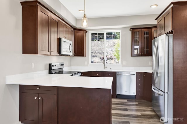 3513 Sussex Dr, Bellingham, WA 98226 - kitchen with a sink, a peninsula, wood finished floors, light countertops, and appliances with stainless steel finishes