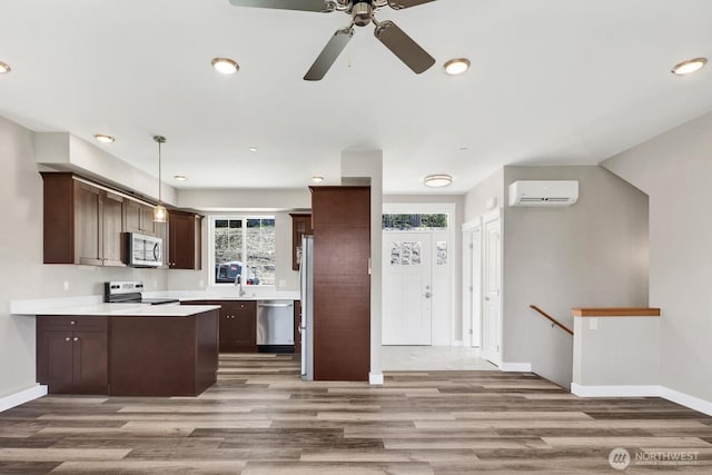 3513 Sussex Dr, Bellingham, WA 98226 - kitchen with a wall mounted air conditioner, light wood-style floors, dark brown cabinetry, ceiling fan, and appliances with stainless steel finishes