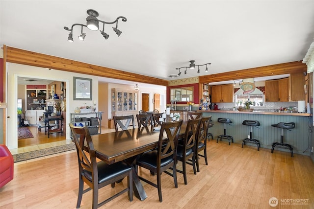 dining area with light wood-type flooring and rail lighting