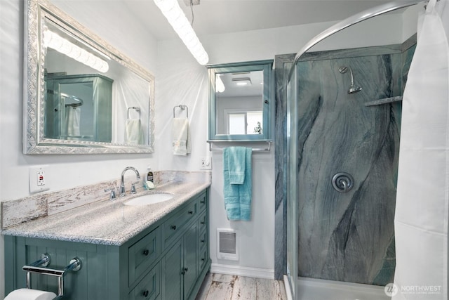 full bath with visible vents, vanity, and a marble finish shower