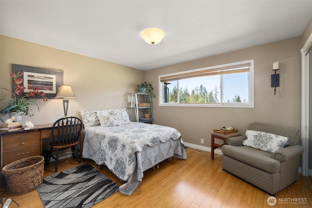 bedroom featuring baseboards, visible vents, and light wood-type flooring