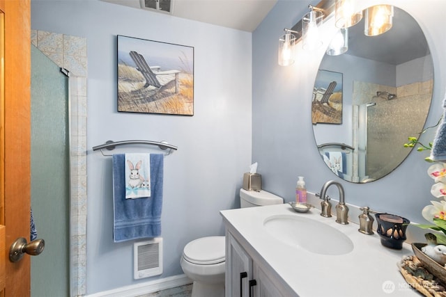 bathroom featuring toilet, visible vents, vanity, and a stall shower