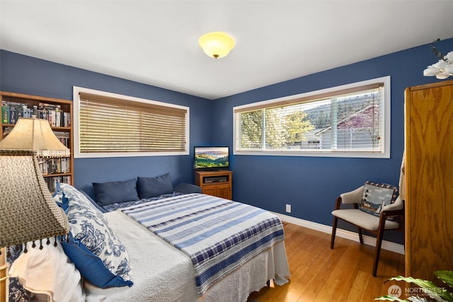 bedroom with baseboards and hardwood / wood-style floors