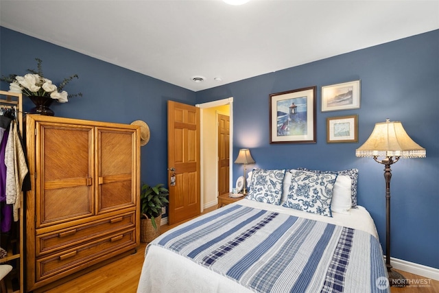 bedroom featuring light wood-style flooring and baseboards