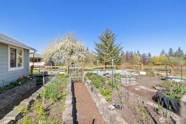 view of yard featuring fence and a vegetable garden
