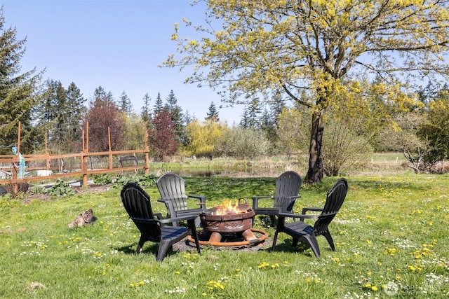 view of yard with fence and an outdoor fire pit