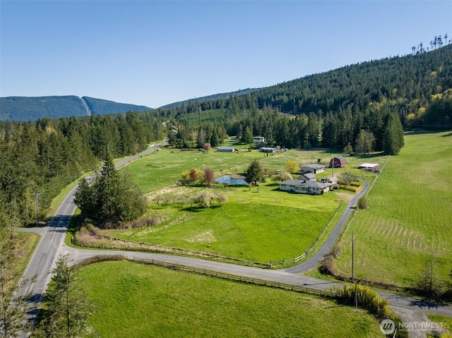 birds eye view of property with a forest view and a mountain view