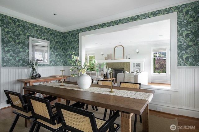 4015 S Andover St, Seattle, WA 98118 - dining area with wood finished floors, a wainscoted wall, a fireplace, and wallpapered walls