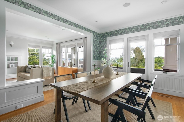 4015 S Andover St, Seattle, WA 98118 - dining room with wallpapered walls, light wood-type flooring, wainscoting, and ornamental molding