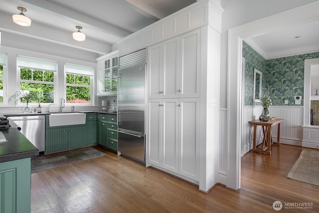 4015 S Andover St, Seattle, WA 98118 - kitchen featuring appliances with stainless steel finishes, green cabinetry, a wainscoted wall, a sink, and white cabinets