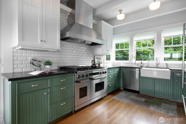 4015 S Andover St, Seattle, WA 98118 - kitchen featuring green cabinets, appliances with stainless steel finishes, wall chimney exhaust hood, a sink, and white cabinets