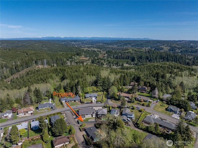 aerial view featuring a forest view and a residential view