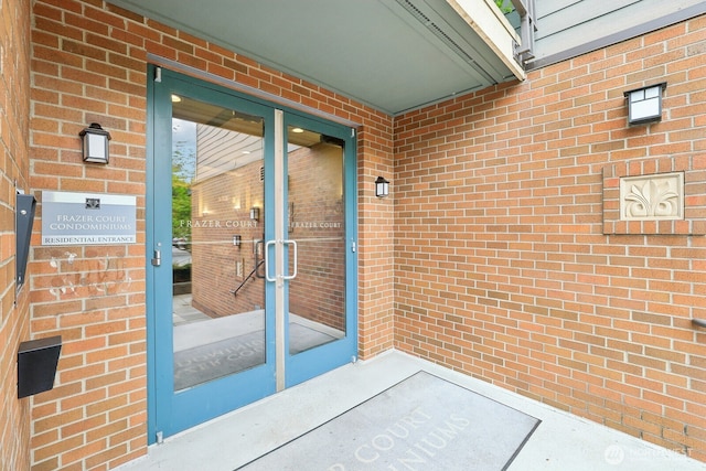 property entrance with brick siding and french doors