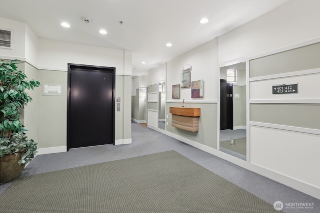 interior space with recessed lighting, elevator, light carpet, and baseboards