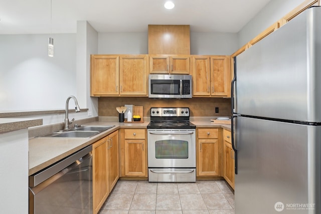 kitchen featuring pendant lighting, appliances with stainless steel finishes, a sink, light tile patterned floors, and light countertops