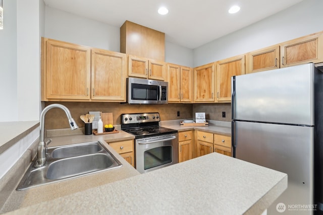 kitchen featuring a sink, light countertops, stainless steel appliances, and recessed lighting