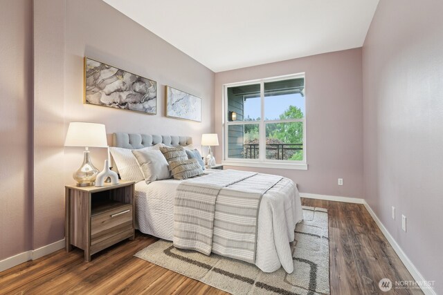 bedroom featuring baseboards and dark wood finished floors