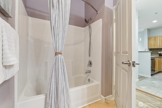 bathroom with tile patterned floors, baseboards, and shower / tub combo with curtain