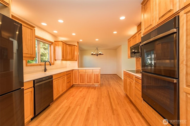 169 Fairway Dr, Sequim, WA 98382 - kitchen with recessed lighting, light countertops, light wood-style floors, black appliances, and a peninsula