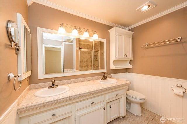 169 Fairway Dr, Sequim, WA 98382 - bathroom with a shower stall, a wainscoted wall, double vanity, ornamental molding, and a sink