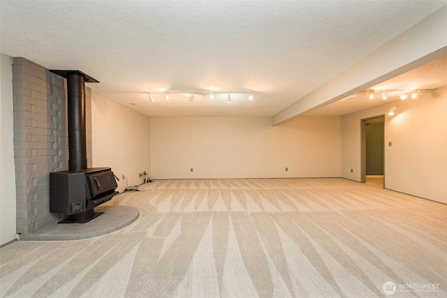 169 Fairway Dr, Sequim, WA 98382 - finished basement with a textured ceiling, track lighting, a wood stove, and light colored carpet