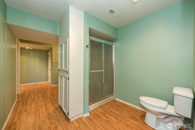 169 Fairway Dr, Sequim, WA 98382 - full bathroom featuring toilet, wood finished floors, visible vents, and a stall shower