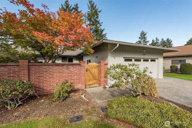 169 Fairway Dr, Sequim, WA 98382 - mid-century modern home with fence, an attached garage, driveway, and a gate