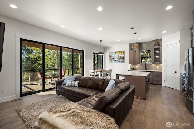 living room featuring baseboards, visible vents, recessed lighting, and dark wood-style flooring