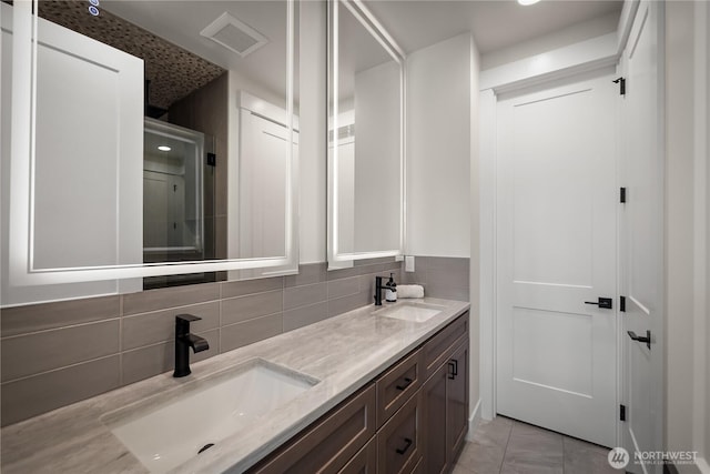 full bathroom featuring backsplash, double vanity, visible vents, and a sink