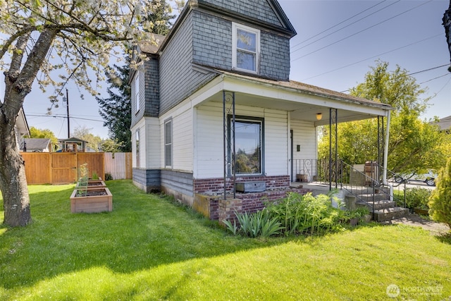 2231 Highland Ave, Everett, WA 98201 - view of front of house with fence, covered porch, a vegetable garden, and a front yard